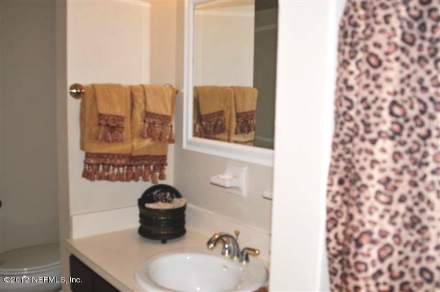 10568 Tulsa Road Jacksonville, FL 32218 - Photo 21 of 31 a bathroom with a sink toilet and a mirror