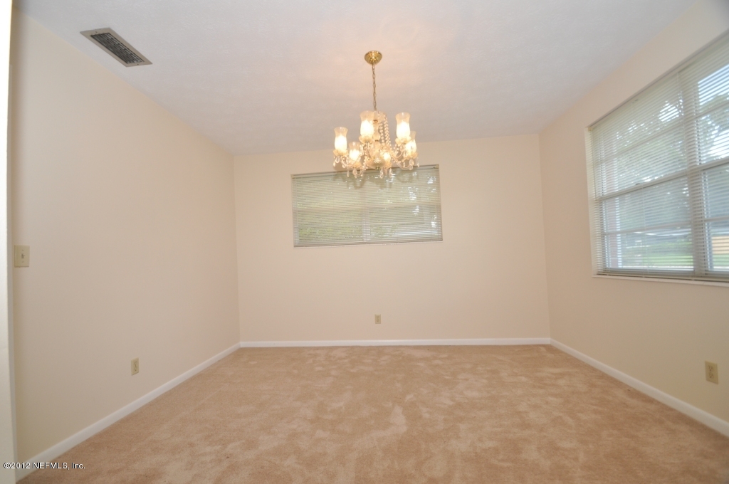 10568 Tulsa Road Jacksonville, FL 32218 - Photo 10 of 31 en empty room with window and chandelier fan