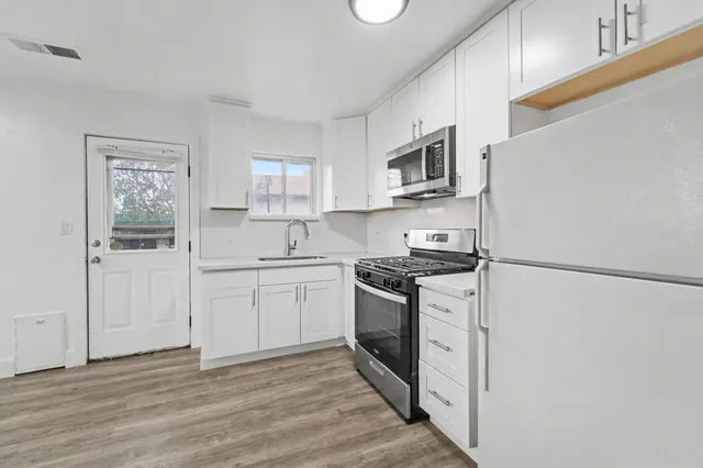 a kitchen with stainless steel appliances granite countertop a refrigerator sink and stove