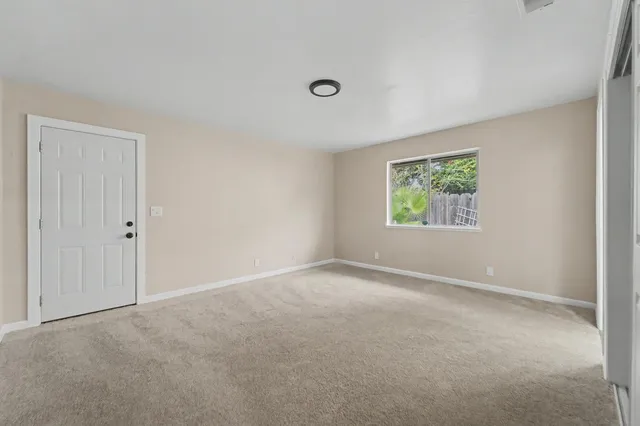 an empty room with windows and closet area