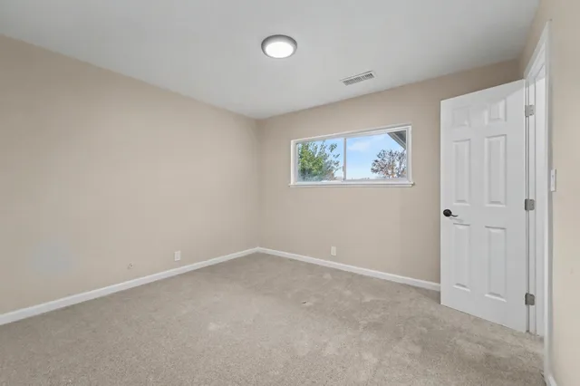 a view of an empty room with a painting on the wall