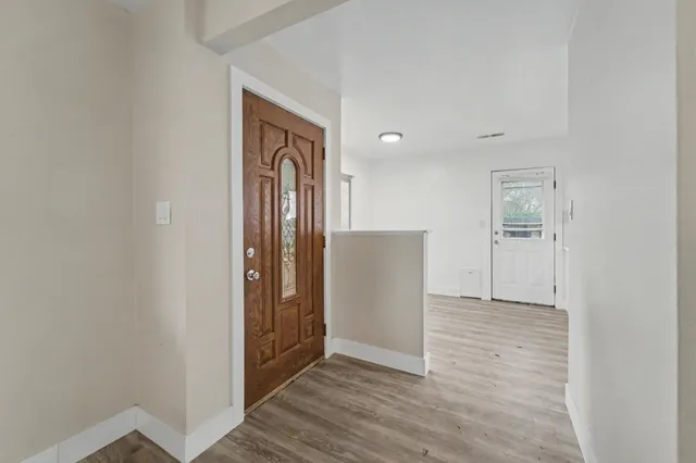 a view of empty room with wooden floor