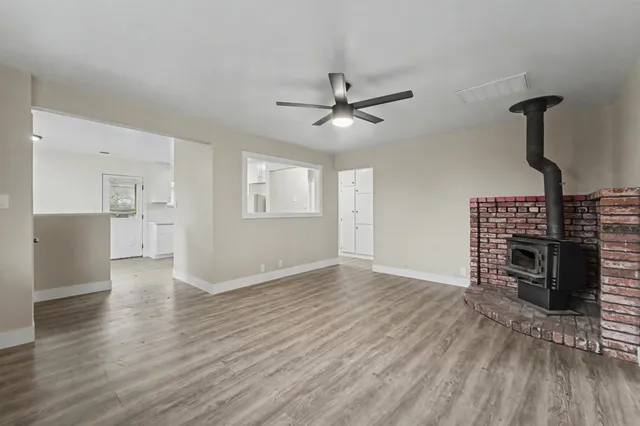 a view of empty room with wooden floor and fireplace