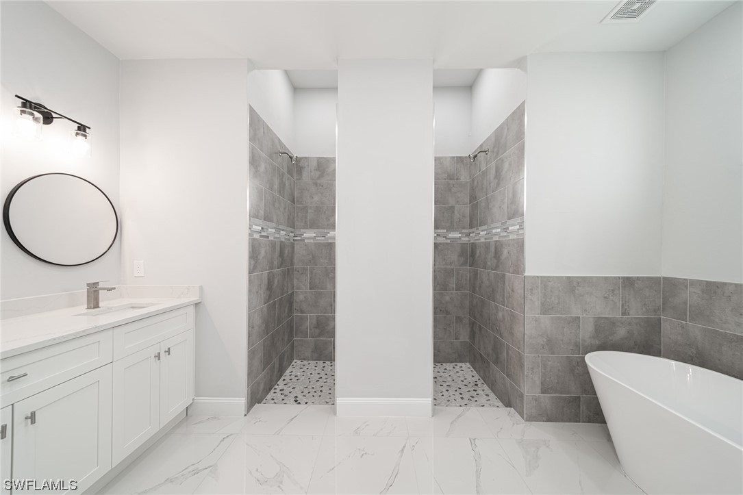 344 Rancho Avenue Lehigh Acres, FL 33974 - Photo 16 of 27 a bathroom with a double vanity sink a toilet and a mirror