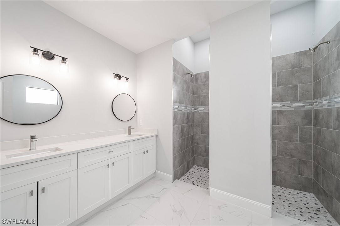 344 Rancho Avenue Lehigh Acres, FL 33974 - Photo 17 of 27 a bathroom with a double vanity sink mirror and shower