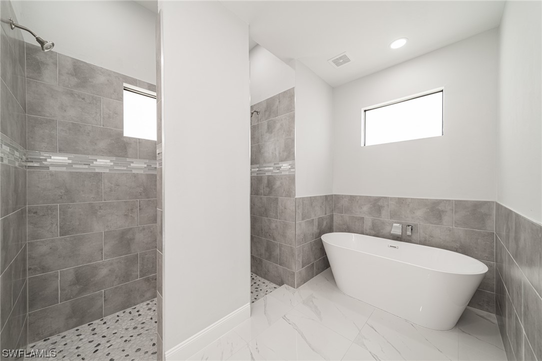 344 Rancho Avenue Lehigh Acres, FL 33974 - Photo 18 of 27 a bathroom with a white tub shower and a sink