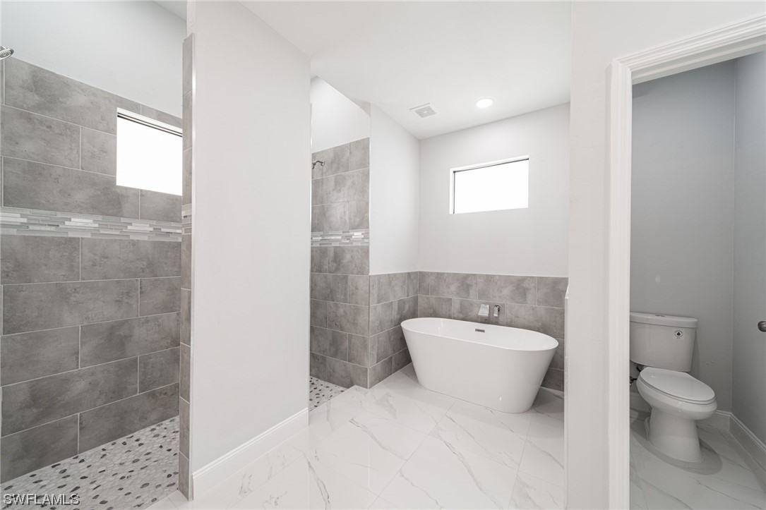 344 Rancho Avenue Lehigh Acres, FL 33974 - Photo 19 of 27 a bathroom with a toilet a sink and mirror