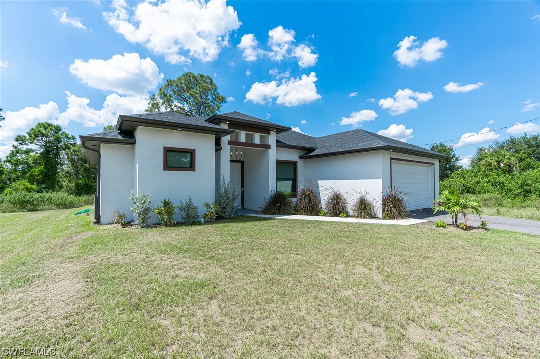 344 Rancho Avenue Lehigh Acres, FL 33974 - Photo 2 of 27 a house view with a garden space