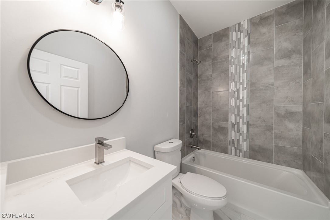 344 Rancho Avenue Lehigh Acres, FL 33974 - Photo 22 of 27 a bathroom with a sink a toilet and a mirror