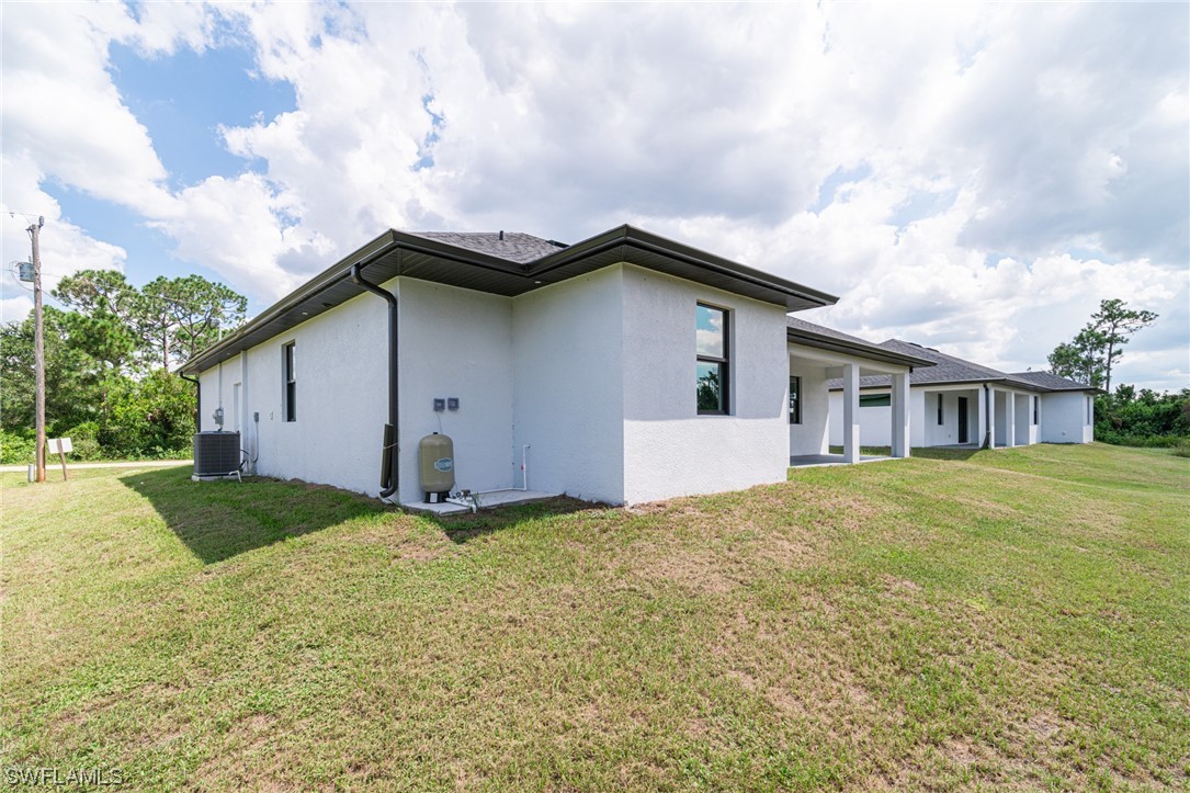 344 Rancho Avenue Lehigh Acres, FL 33974 - Photo 27 of 27 a white house that has a big yard and large trees