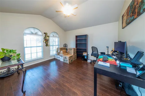 a workspace with furniture hardwood floor and a window