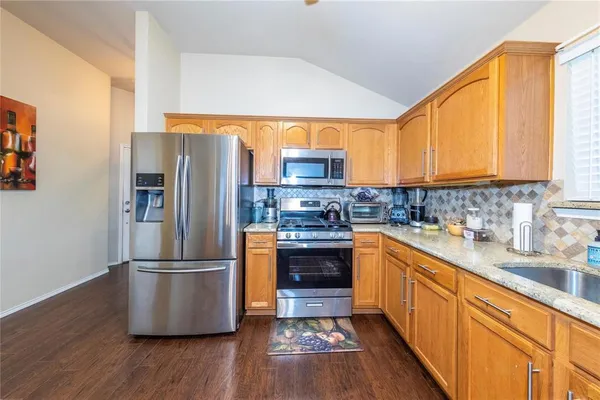 a kitchen with stainless steel appliances granite countertop a refrigerator sink and cabinets
