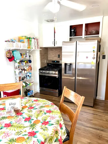 a kitchen with stainless steel appliances kitchen island granite countertop a refrigerator and a stove top oven