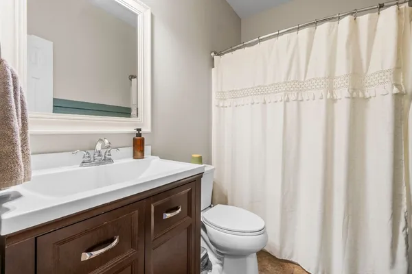 a bathroom with a sink a toilet and a mirror