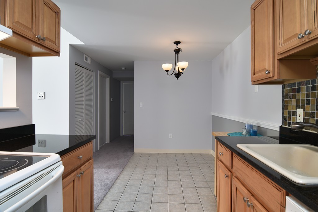 2 Walden Drive, Unit 5 Natick, MA 01760 - Photo 3 of 18 a kitchen with stainless steel appliances granite countertop a sink stove and cabinets