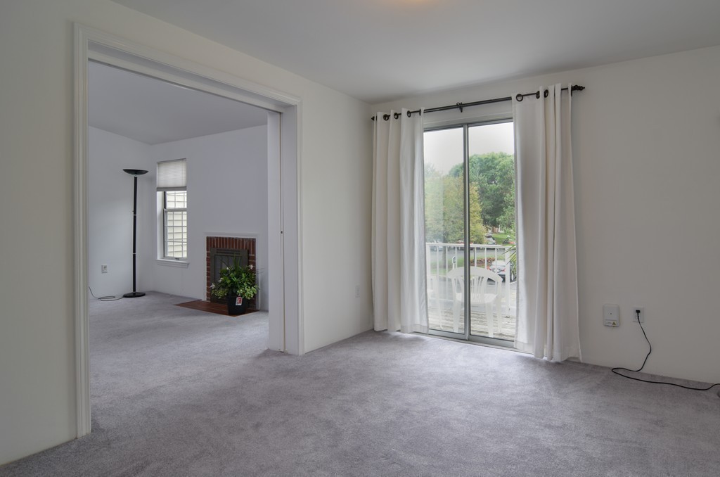 2 Walden Drive, Unit 5 Natick, MA 01760 - Photo 5 of 18 a view of a room with a floor to ceiling window and a kitchen view