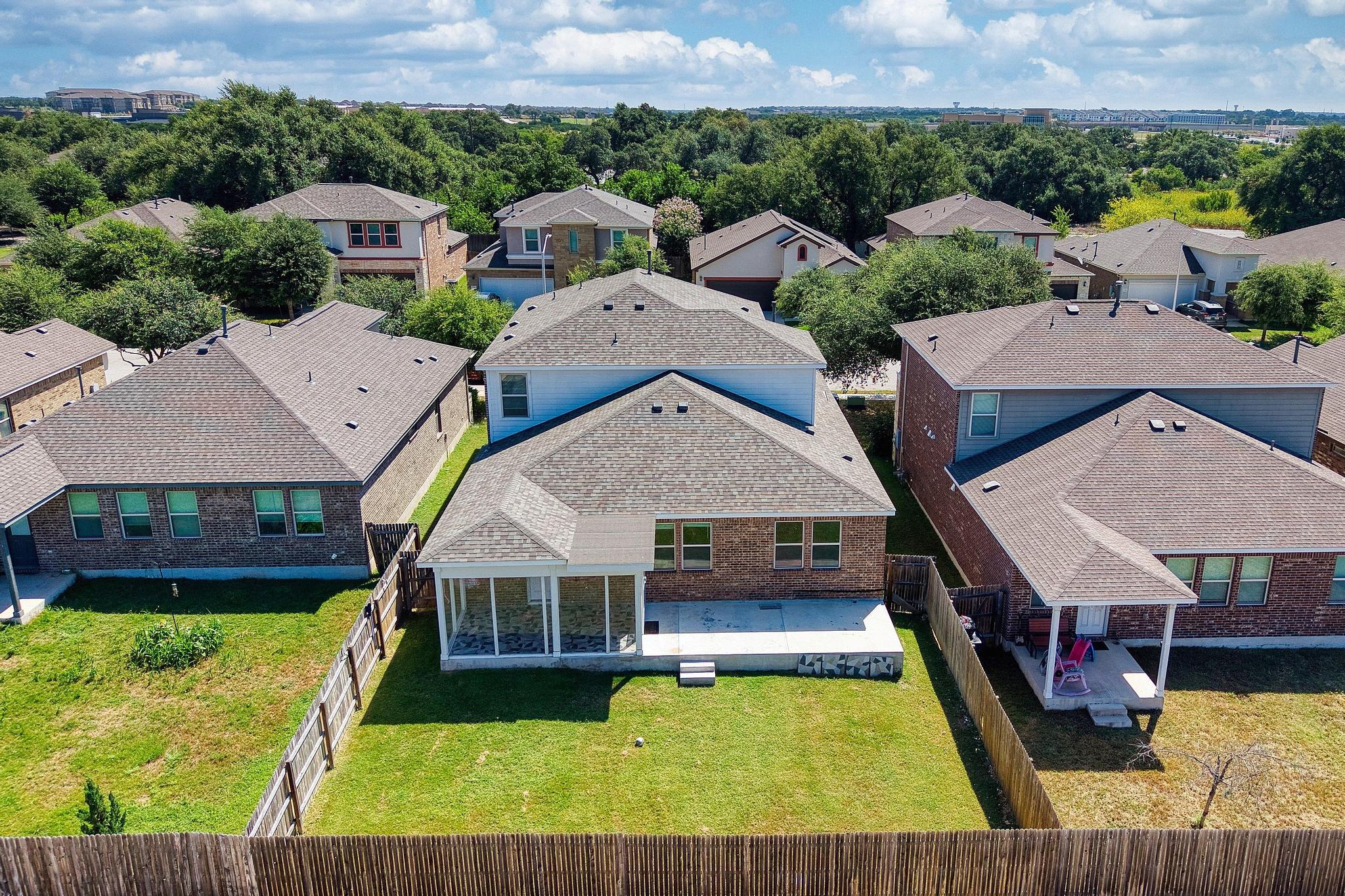 1341 Eagle Ray Street Leander, TX 78641 - Photo 31 of 37 An aerial perspective reveals a quiet suburban neighborhood with residential homes nestled among mature trees and clear skies.