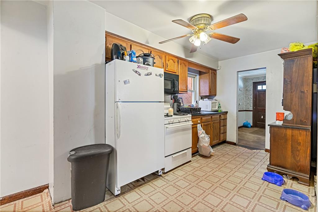 811 6th Street McKees Rocks, PA 15136 - Photo 8 of 19 a kitchen with a refrigerator a stove top oven cabinets and a dining table