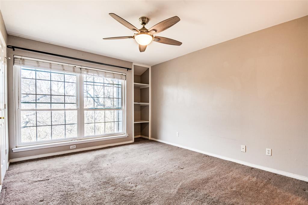 9801 Royal Lane, Unit 711 Dallas, TX 75231 - Photo 13 of 23 an empty room with windows and ceiling fan