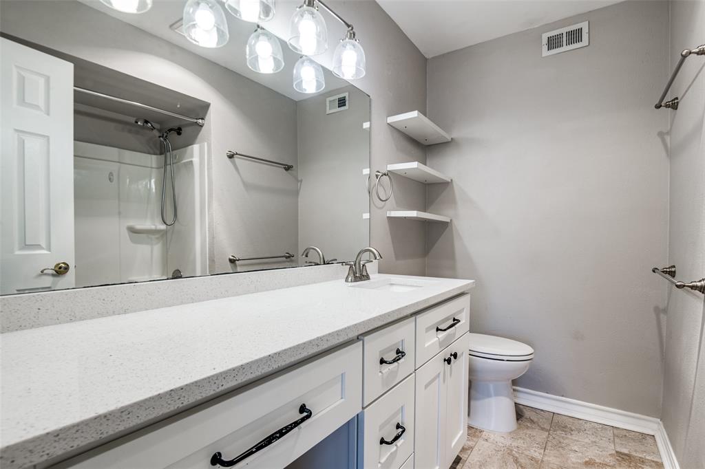 9801 Royal Lane, Unit 711 Dallas, TX 75231 - Photo 16 of 23 a bathroom with a sink a toilet and a mirror