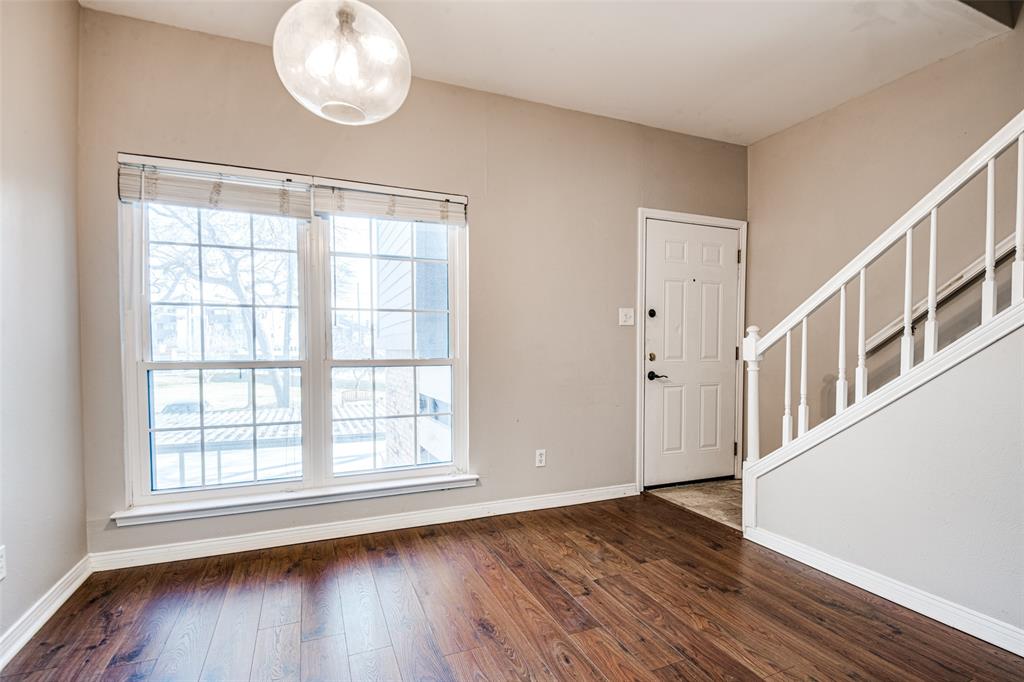 9801 Royal Lane, Unit 711 Dallas, TX 75231 - Photo 2 of 23 an empty room with wooden floor and windows
