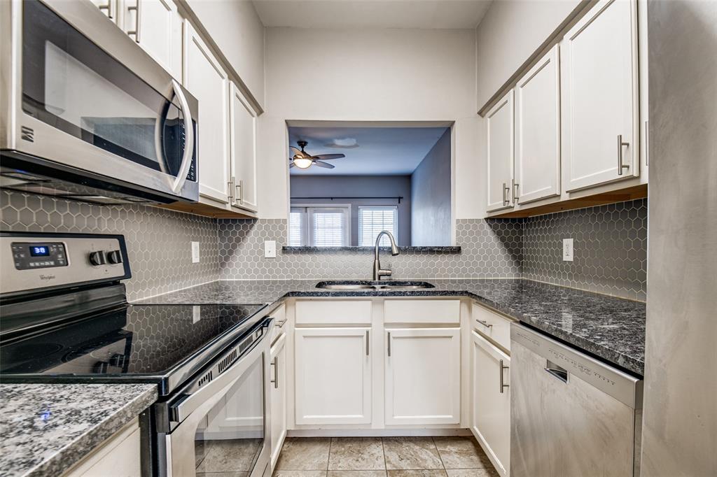 9801 Royal Lane, Unit 711 Dallas, TX 75231 - Photo 4 of 23 a kitchen with stainless steel appliances granite countertop a sink stove and cabinets