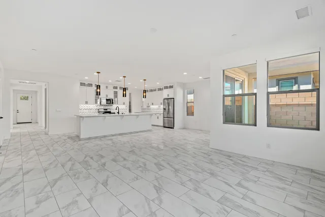 a kitchen with stainless steel appliances kitchen island granite countertop a sink and white cabinets