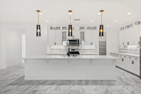 a kitchen with stainless steel appliances a stove a sink and a microwave