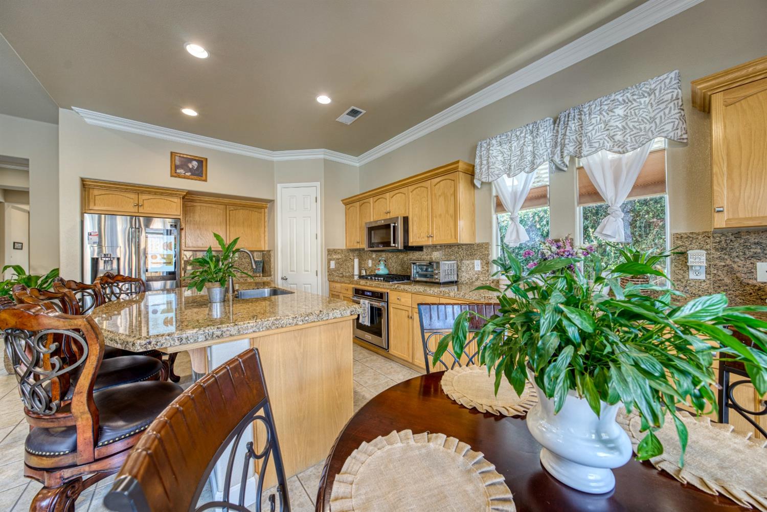 143 West Bedford Avenue Clovis, CA 93611 - Photo 21 of 55 a living room with furniture potted plant floor to ceiling windows and a flat screen tv