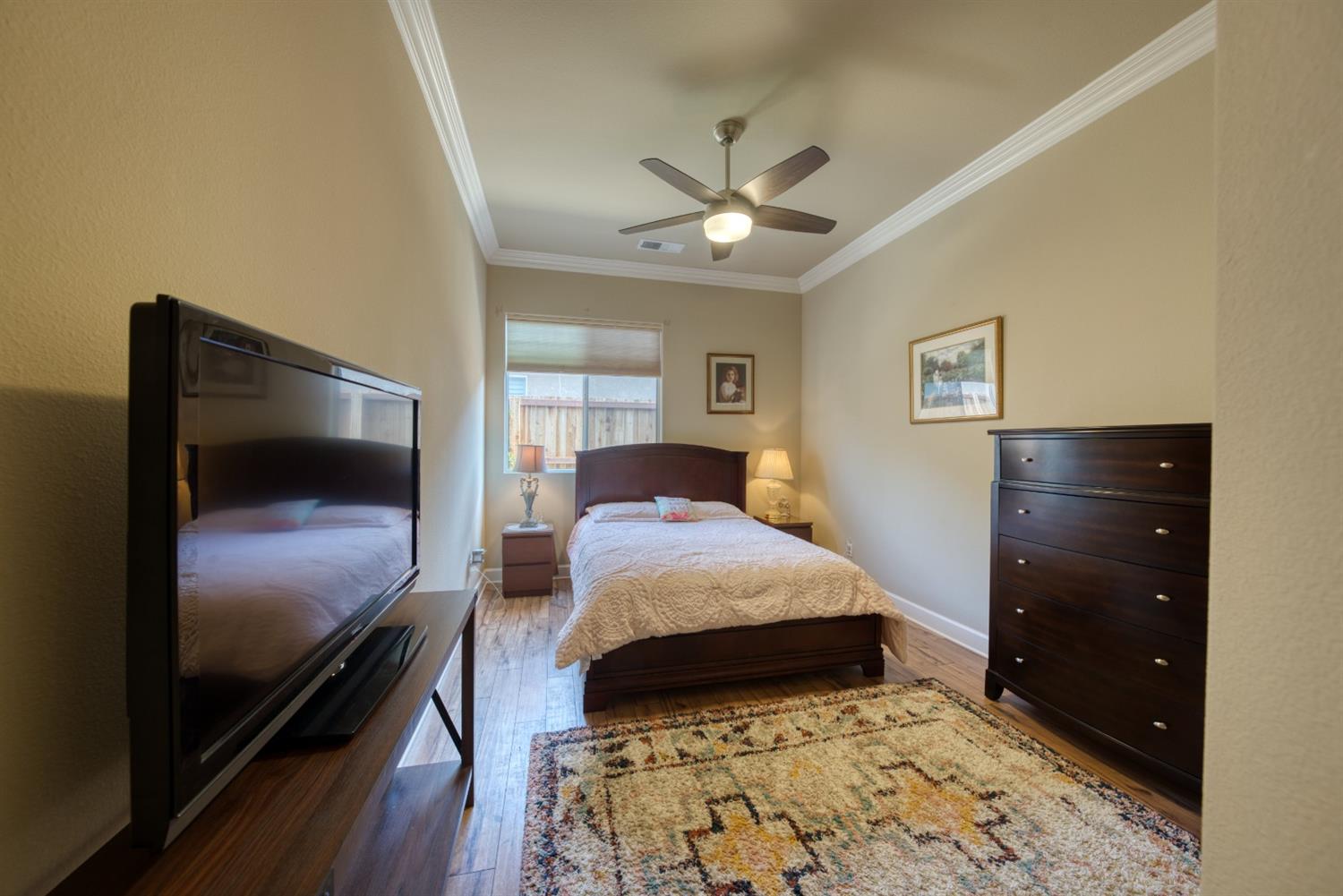 143 West Bedford Avenue Clovis, CA 93611 - Photo 39 of 55 a bedroom with a bed and a flat tv screen on dresser
