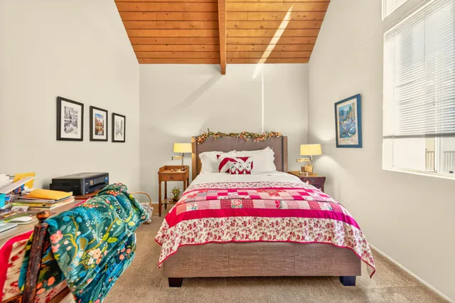 a bedroom with a bed a dresser and a window