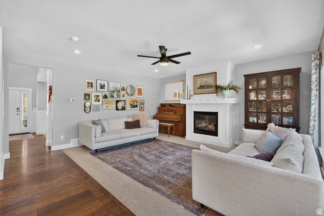 1263 East 1200th South Springville, UT 84663 - Photo 32 of 60 Living space featuring wood-finish flooring, a white mantel fireplace with a dark firebox, and a ceiling fan with integrated lighting