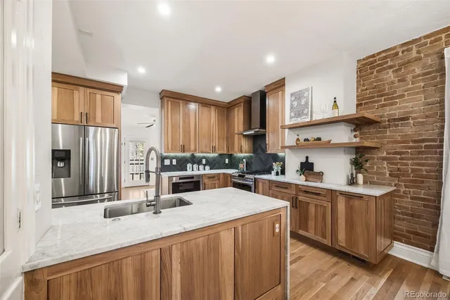 a kitchen with stainless steel appliances granite countertop a sink stove and refrigerator