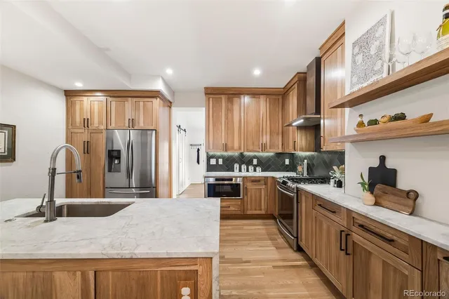 a kitchen with stainless steel appliances granite countertop a sink refrigerator and cabinets