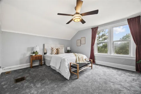 a bed sitting in a spacious bedroom next to a window