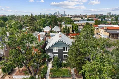 a view of a house with a yard and large trees
