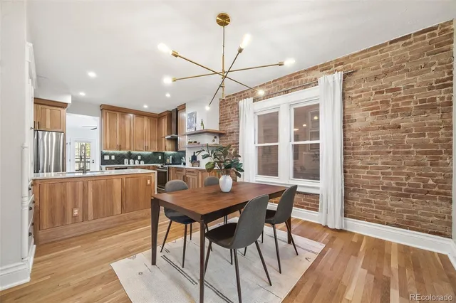 a dining room with stainless steel appliances kitchen island granite countertop a dining table chairs and granite counter tops
