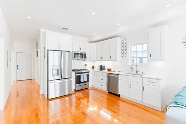 a kitchen with white cabinets and stainless steel appliances