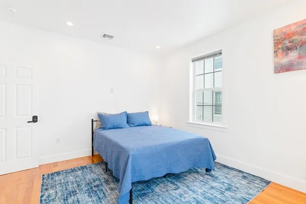 a bedroom with a bed and wooden floor
