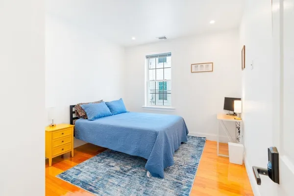 a bedroom with a bed and wooden floor