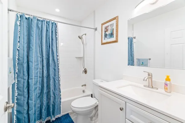 a bathroom with a sink a toilet and shower curtain