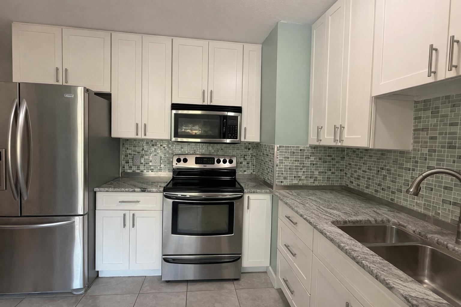 238 Martisa Road Northwest Fort Walton Beach, FL 32548 - Photo 10 of 48 a kitchen with white cabinets and stainless steel appliances