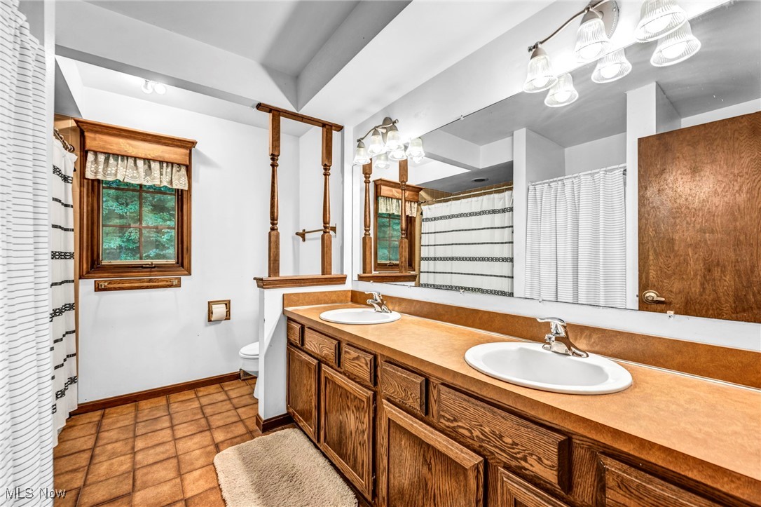 12938 Carter Road Painesville, OH 44077 - Photo 39 of 50 Full bath with double vanity, curtained shower, and tile patterned flooring