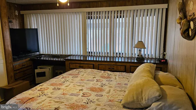 a bedroom with a bed and a flat tv screen