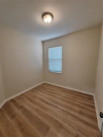 a view of an empty room with closet and a window