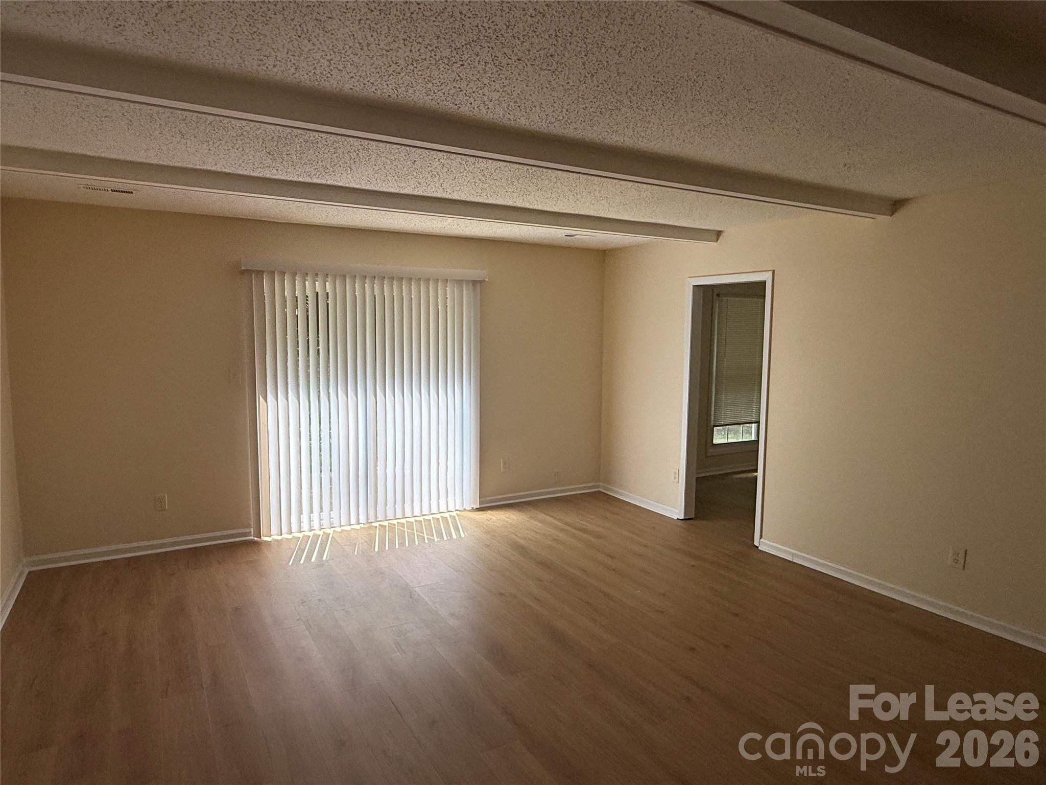 6341 Round Hill Road Charlotte, NC 28211 - Photo 2 of 16 a view of an empty room with wooden floor and a window