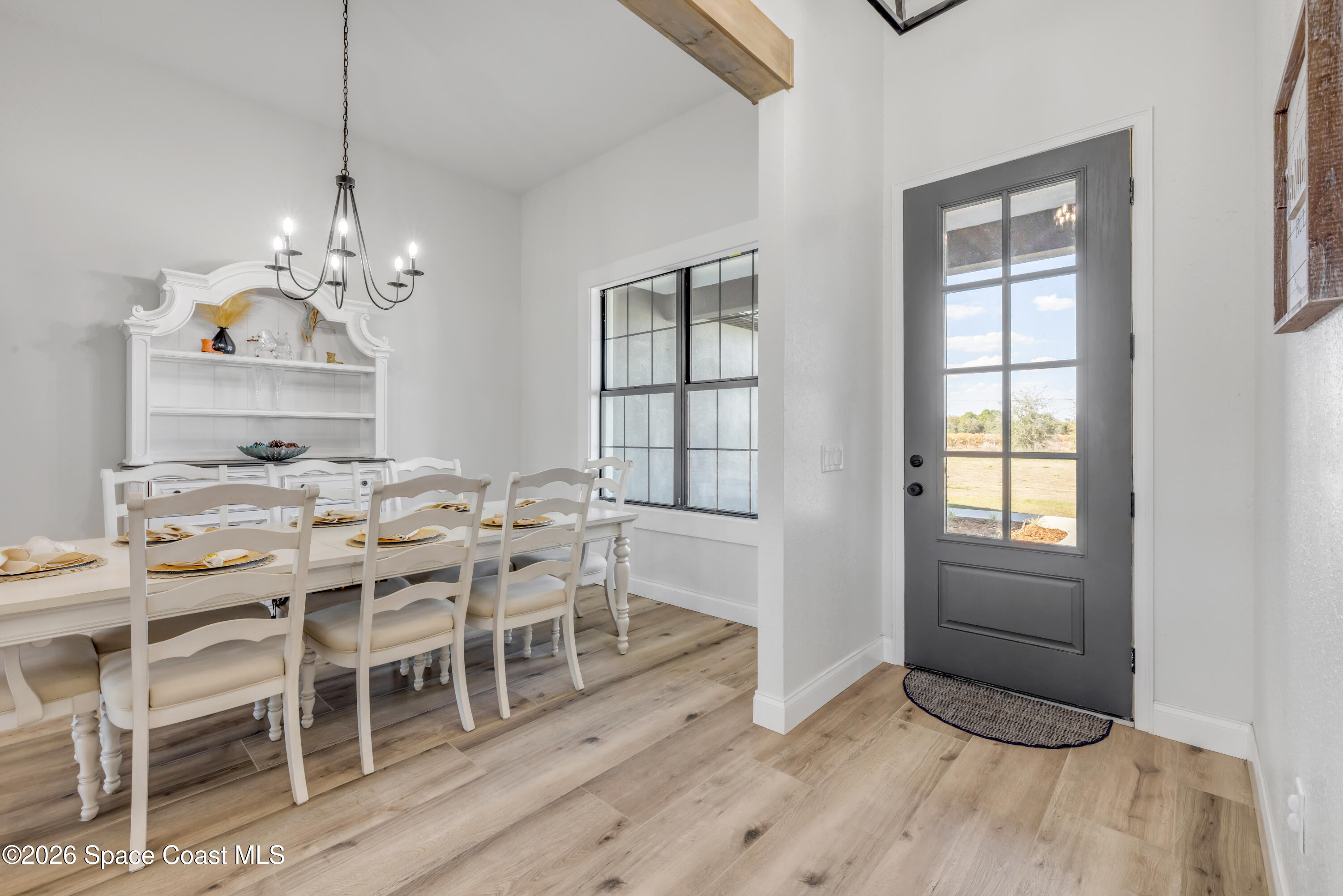 3395 Dunn Road Mims, FL 32754 - Photo 6 of 40 a dining room with wooden floor a chandelier a wooden table and chairs
