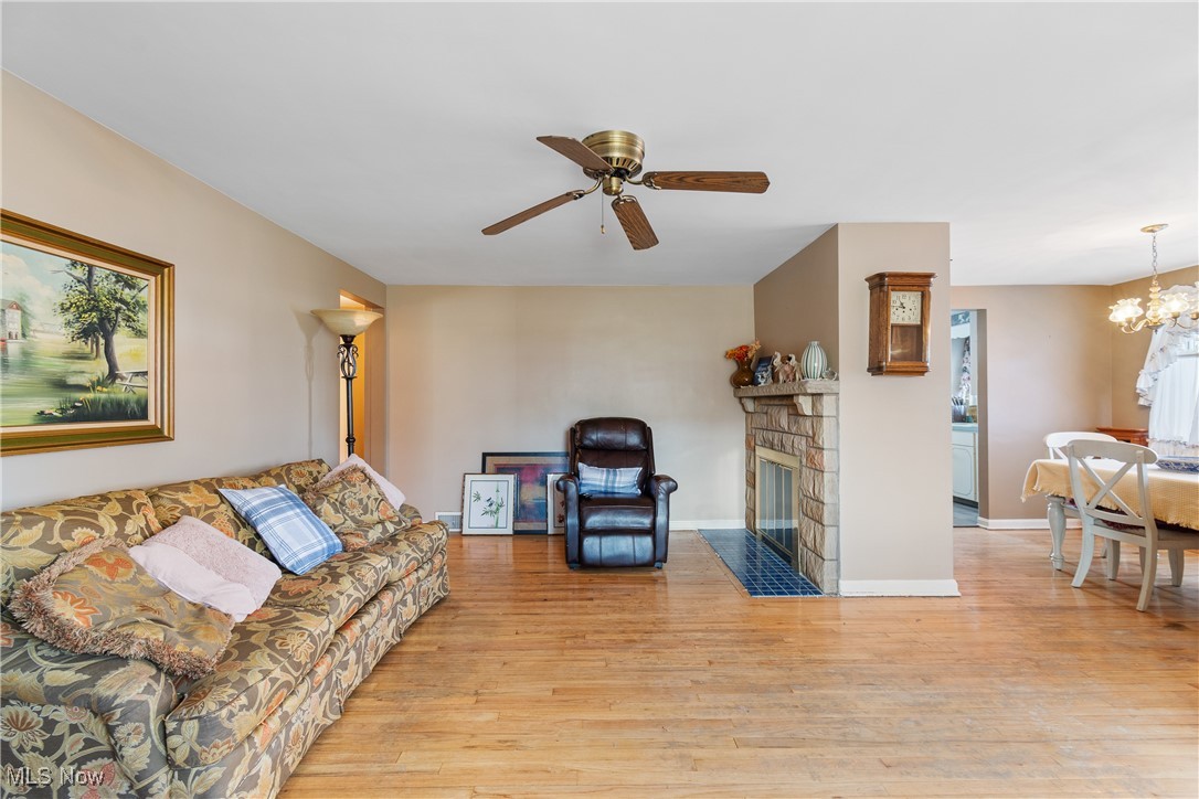 1527 Ridge Road Northwest Canton, OH 44703 - Photo 6 of 27 Living room featuring ceiling fan with notable chandelier and light wood-type flooring