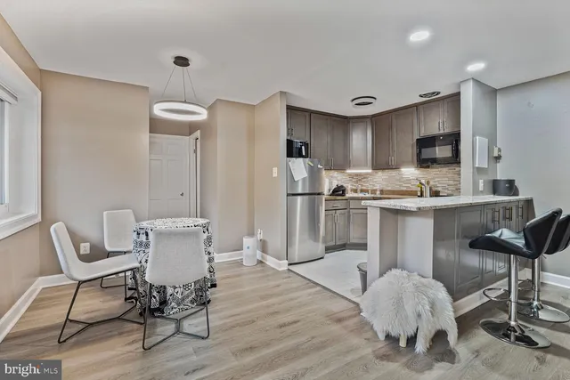 a kitchen with a dining table chairs and refrigerator