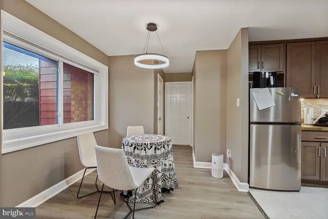 a kitchen with stainless steel appliances a refrigerator a table and chairs